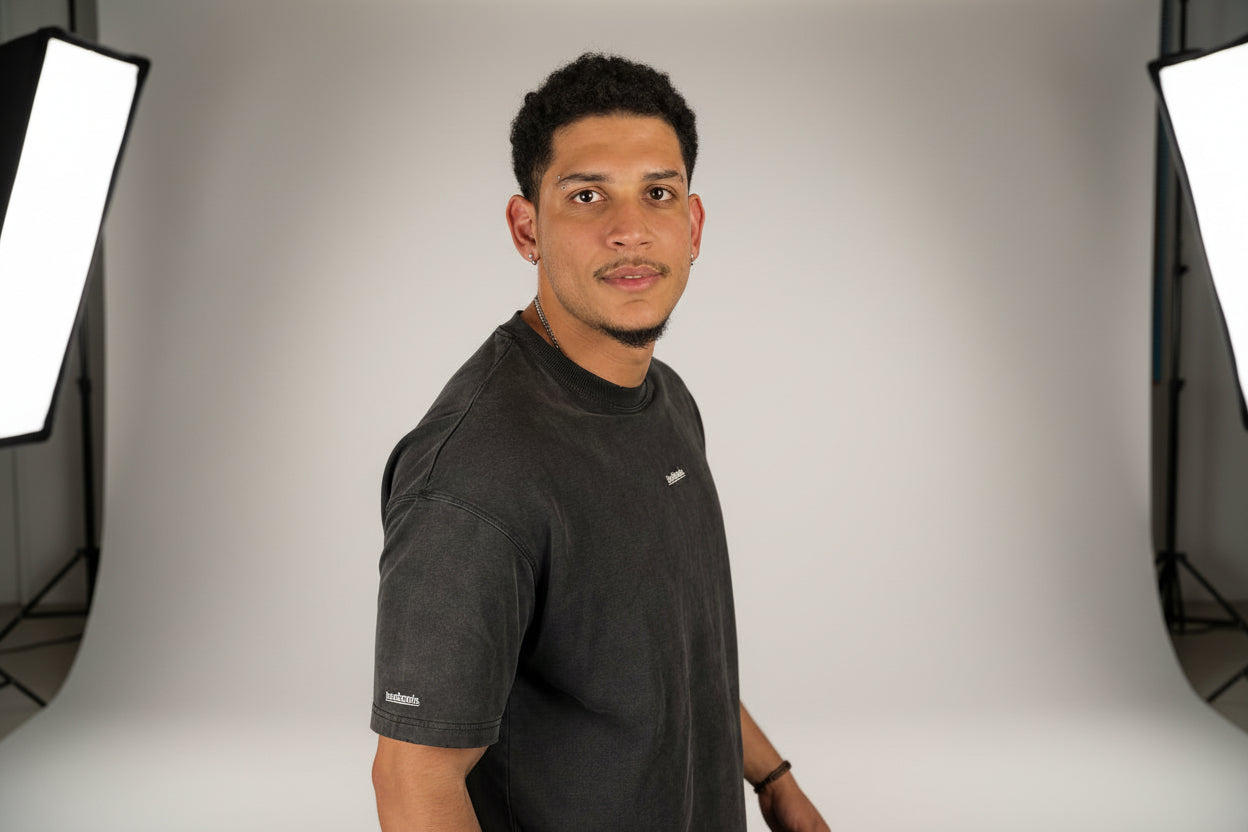 Man wearing a BLACK t-shirt against a black background